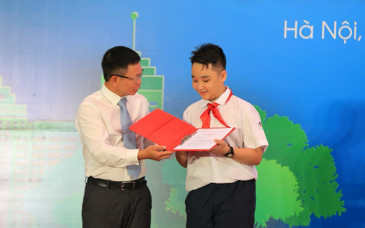 Em Nguyễn Trí Huy, học sinh lớp 7H, Trường THCS Trưng Vương (bên phải) đại diện học sinh nhà trường nhận bài dự thi từ Trưởng Ban tổ chức cuộc thi Giấc Mơ Xanh, Nhà báo Phùng Công Sưởng, Phó tổng biên tập phụ trách Báo Tiền Phong. Ảnh: Trọng Tài Em Nguyễn Trí Huy, học sinh lớp 7H, Trường THCS Trưng Vương (bên phải) đại diện học sinh nhà trường nhận bài dự thi từ Trưởng Ban tổ chức cuộc thi Giấc Mơ Xanh, Nhà báo Phùng Công Sưởng, Phó tổng biên tập phụ trách Báo Tiền Phong. Ảnh: Trọng Tài