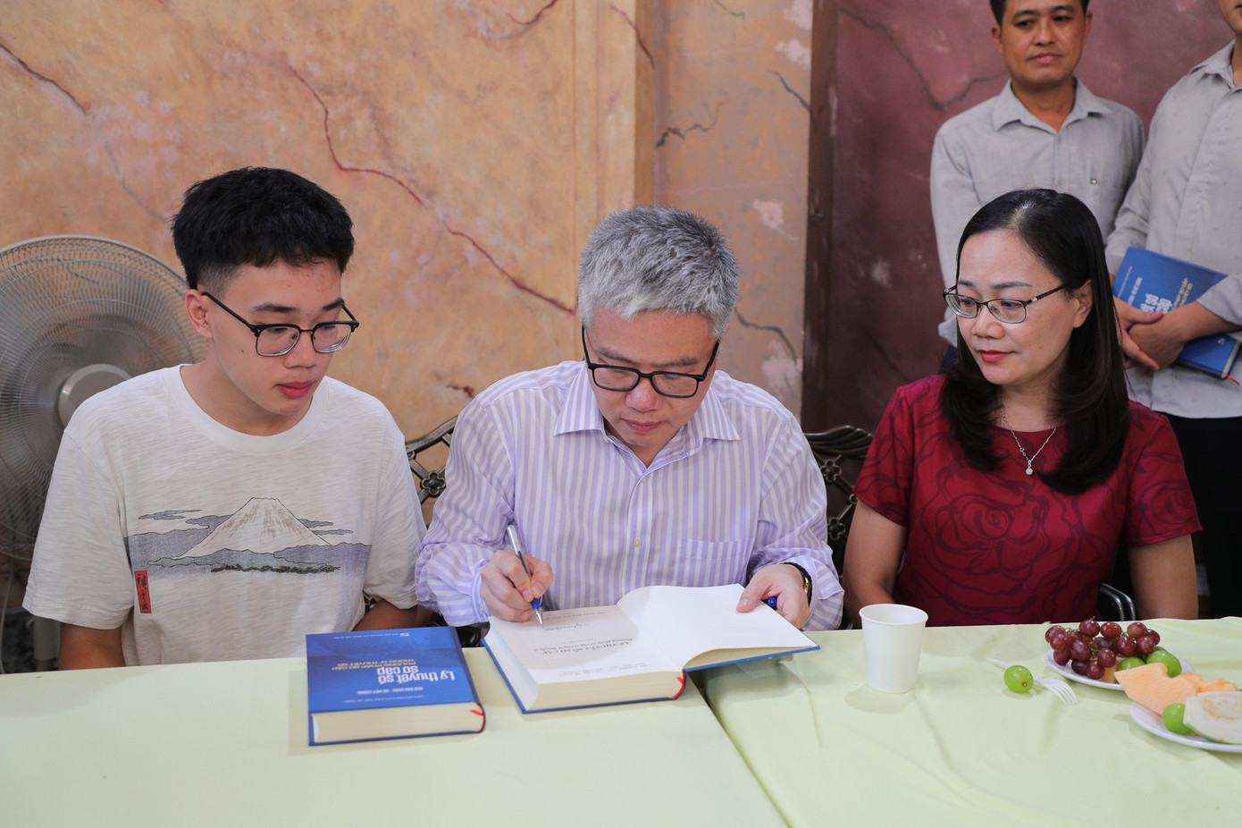 Giáo sư Ngô Bảo Châu (ngồi giữa) kí tặng cho độc giả.