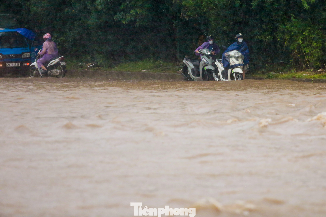 Nhiều phương tiện chọn cách dắt xe dọc dải phân cách để băng qua biển nước.