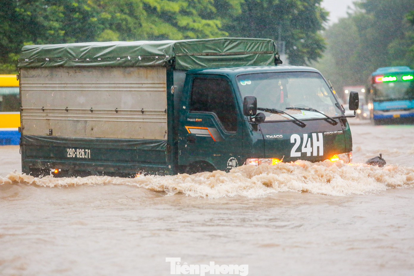 Nước ngập quá bánh xe nhưng người dân cố gắng vượt qua điểm ngập sâu qua Đại lộ Thăng Long.