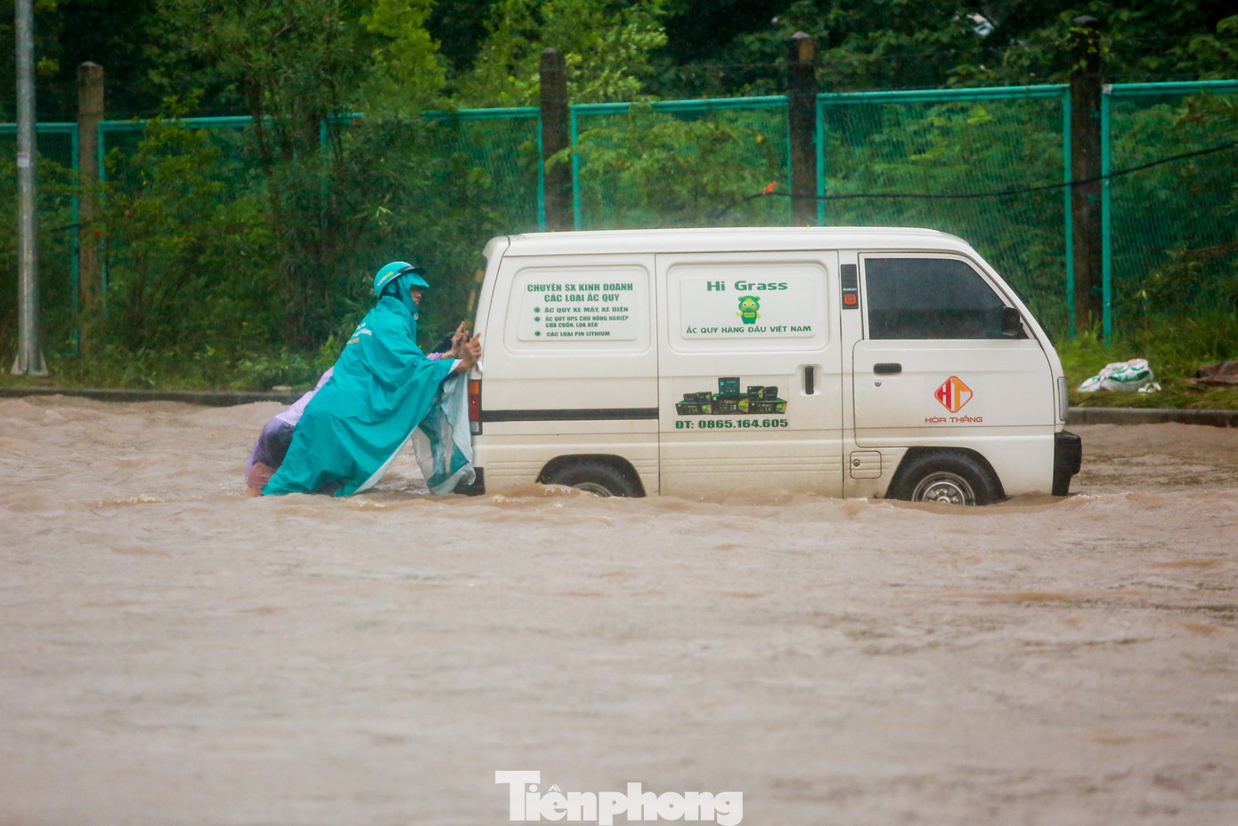 Ô tô chết máy phải nhờ 2-3 người đẩy ra khỏi biển nước.
