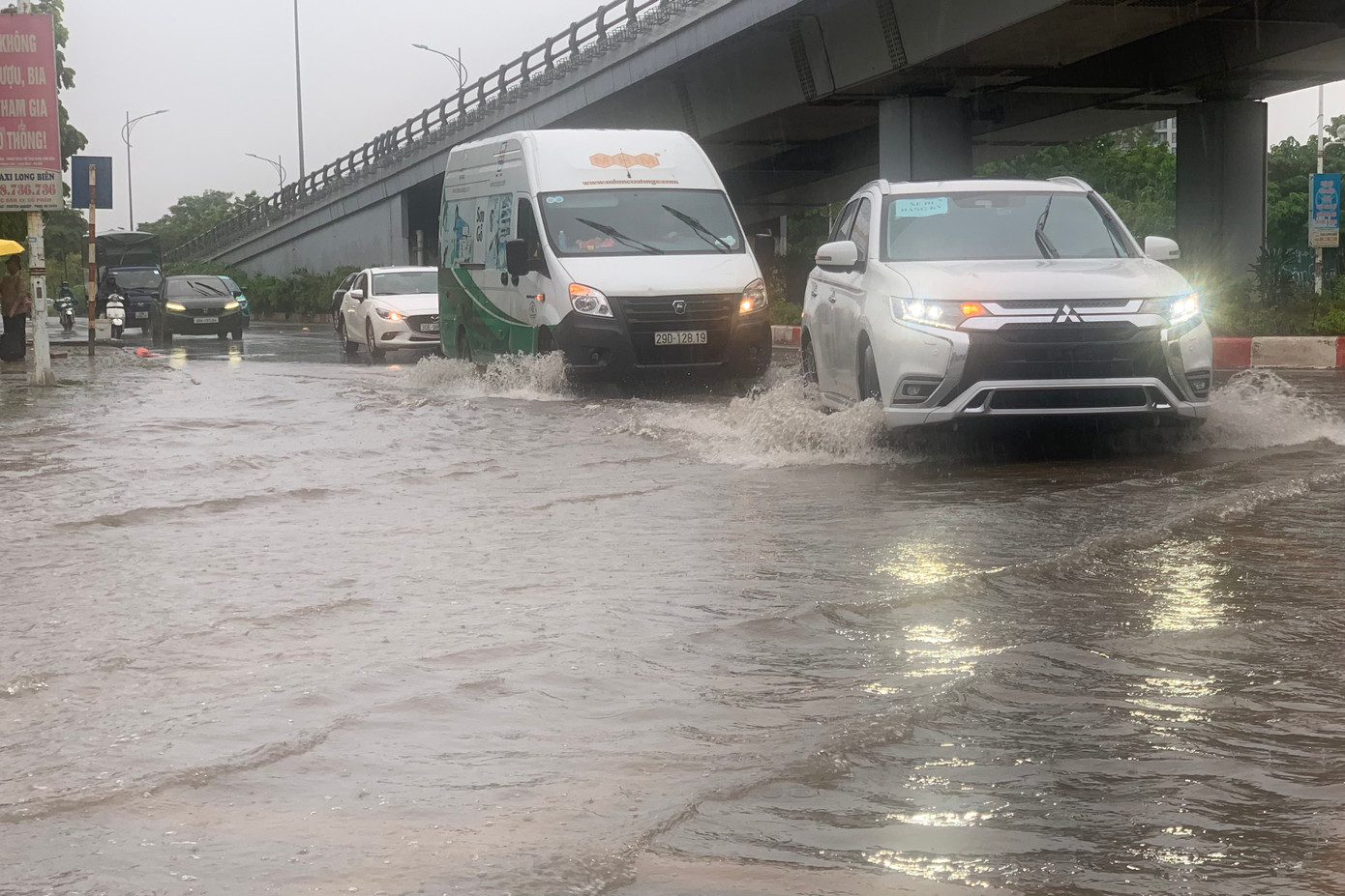 Các phương tiện di chuyển chậm qua đoạn ngập, giao thông nhanh chóng ùn tắc.
