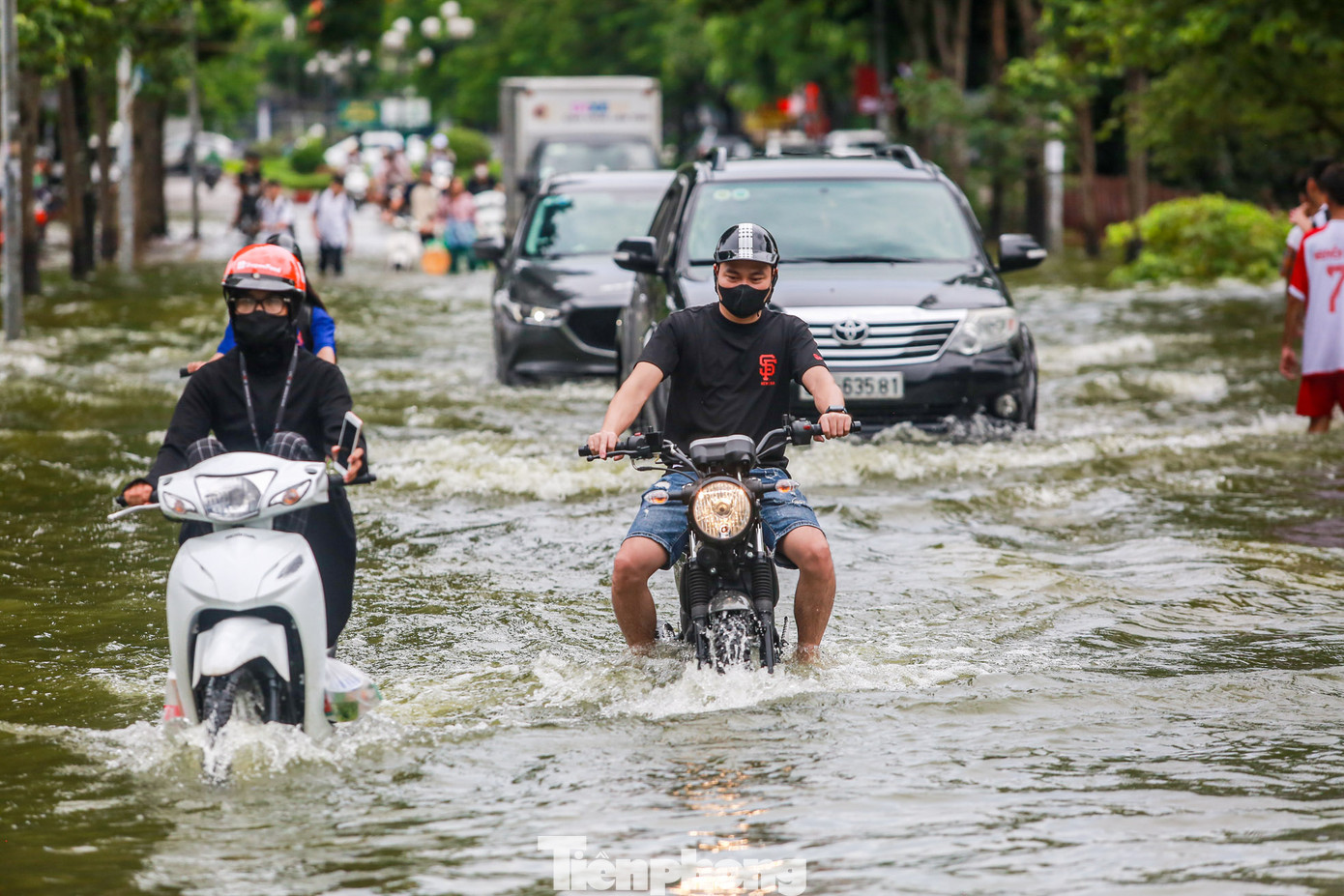 Nước ngập sâu đến 1m, cao gần bánh xe, nhiều phương tiện vẫn liều mình chạy qua.
