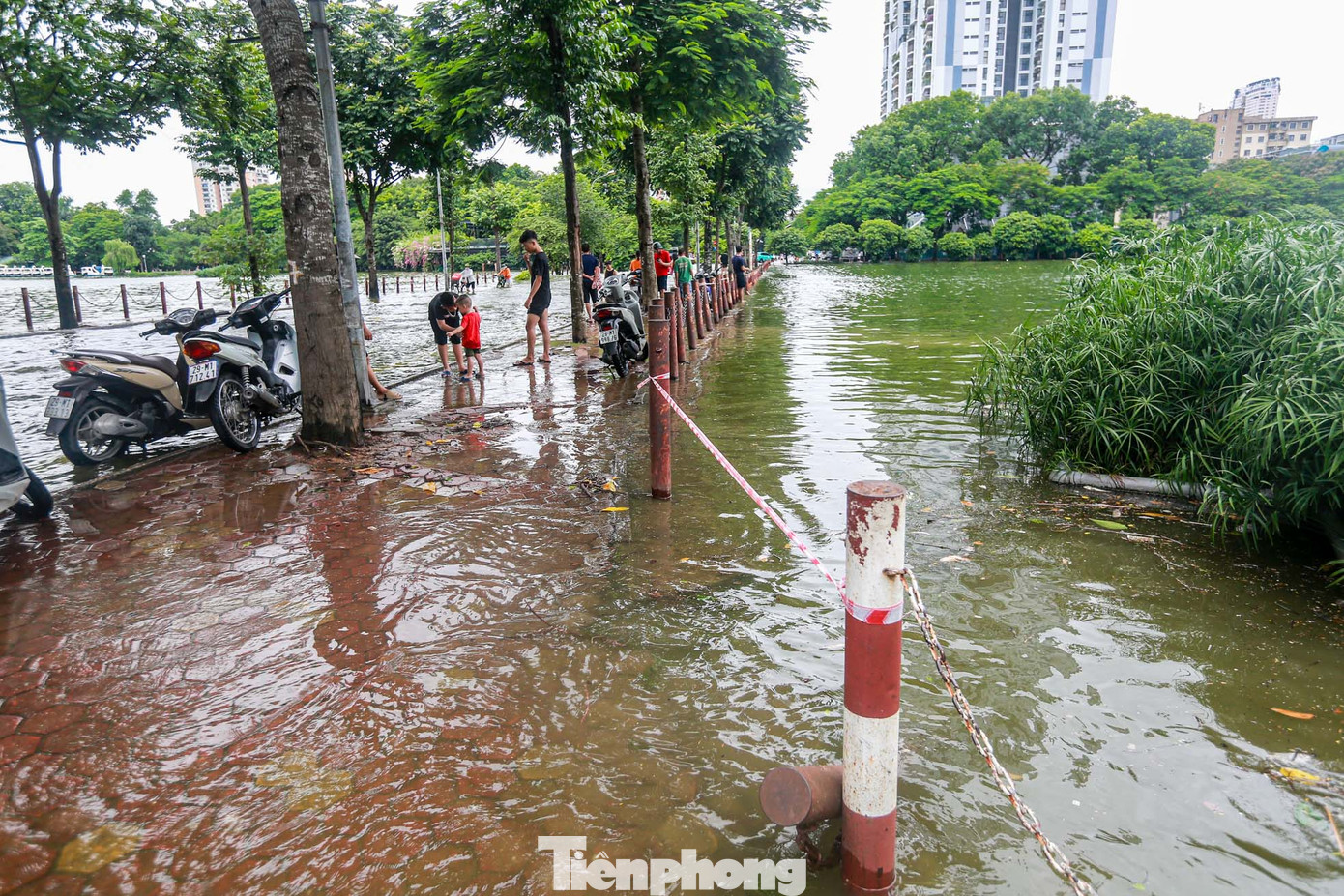 Sau mưa lớn hàng giờ, nước hồ dâng cao, tràn lên đường.