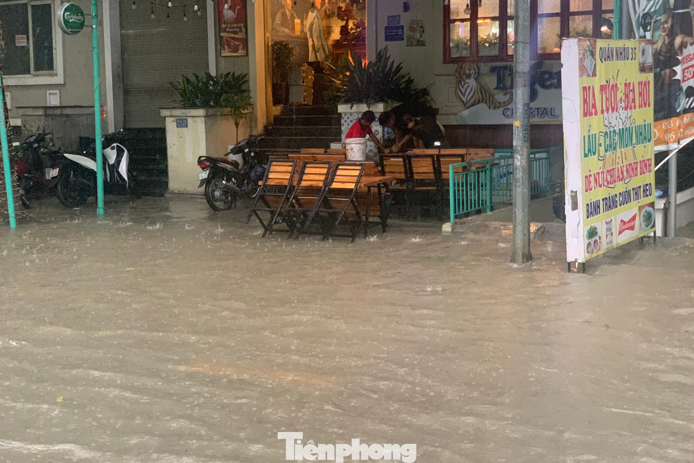 Hàng quán dọn bàn ghế khi nước tràn qua vỉa hè.