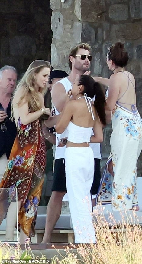 Trong kỳ nghỉ không có vợ ở bên, Chris trông thoải mái khi đứng giữa những phụ nữ diện bikini gợi cảm. Anh mặc áo ba lỗ và quần lửng màu đen khoe cơ bắp rắn rỏi.