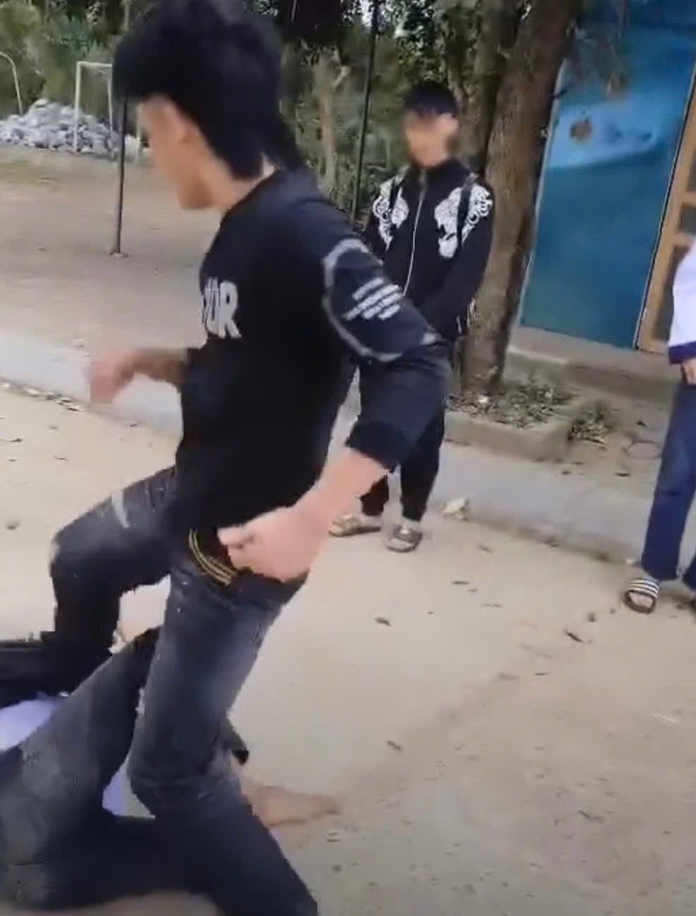 Nam sinh bị đánh gục xuống đất. Ảnh cắt từ clip. Nam sinh bị đánh gục xuống đất. Ảnh cắt từ clip.