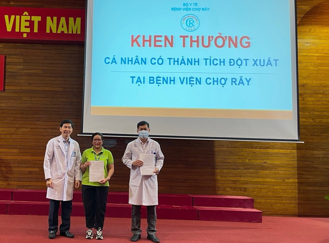 Ban giám đốc Bệnh viện Chợ Rẫy trao thưởng đột xuất cho nhân viên y tế Thanh Thương (người đứng giữa)