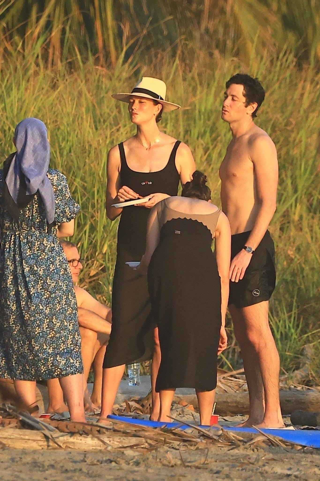 Karlie Kloss thưởng thức đồ ăn trên bờ cùng chồng và những thành viên khác trong gia đình. Trong khi đó, chồng Ivanka lội nước dọc bãi biển. Ảnh: BackGrid.