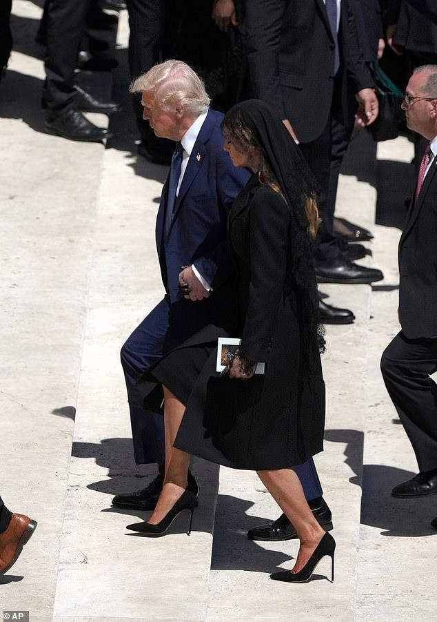 Ông Trump bị chỉ trích vì mặc bộ đồ xanh nổi bật giữa hàng nghìn người mặc trang phục đen. Trong khi đó, bà Melania không để xảy ra sai sót nào. Ảnh: Getty Images/AP.