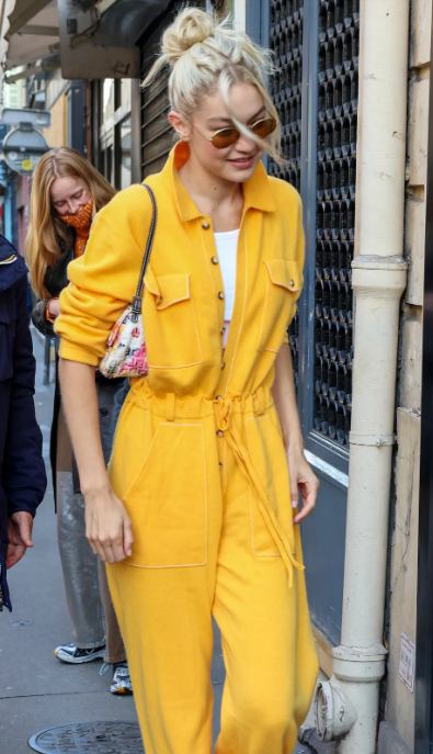 Túi mini họa tiết hoa cùng bộ đồ liền quần màu vàng khiến Gigi bừng sáng giữa phố. Túi mini họa tiết hoa cùng bộ đồ liền quần màu vàng khiến Gigi bừng sáng giữa phố.