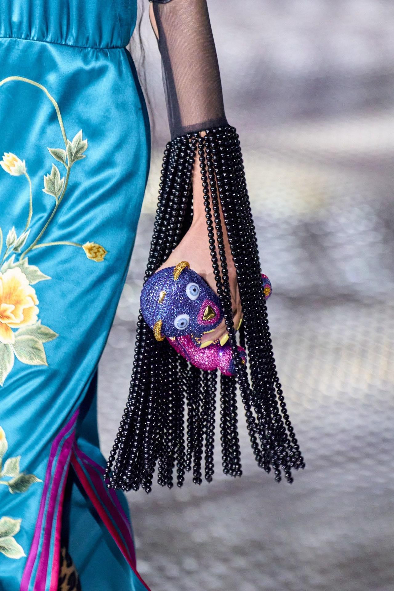 Hòa vào dòng ánh kim lấp lánh, Gucci với clutch cầm tay gấu là điểm nhấn lạ cho BST.