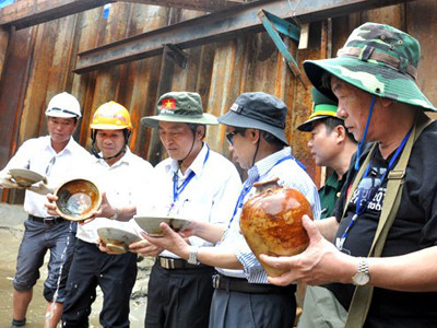 Các chuyên gia giám định cổ vật được khai quật từ con tàu đắm ở vùng biển Bình Châu. Ảnh: Trí Tín