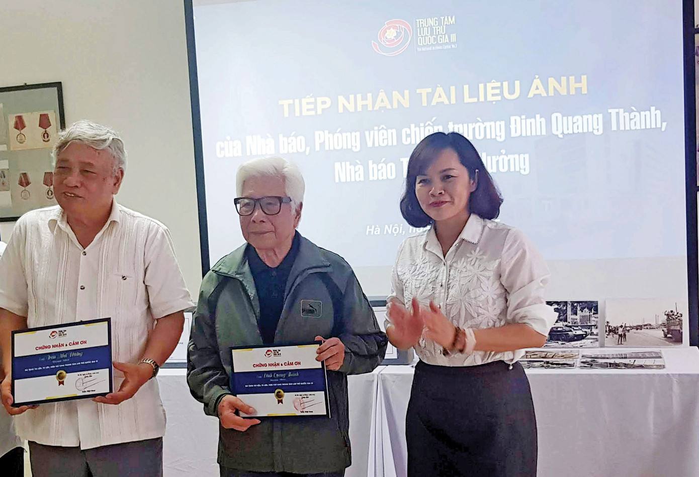 Nhà báo Trần Mai Hưởng (bìa trái) và nhà báo Đinh Quang Thành trong lễ trao tặng những bức ảnh tư liệu tại Trung tâm Lưu trữ Quốc gia III. Ảnh: KIẾN NGHĨA