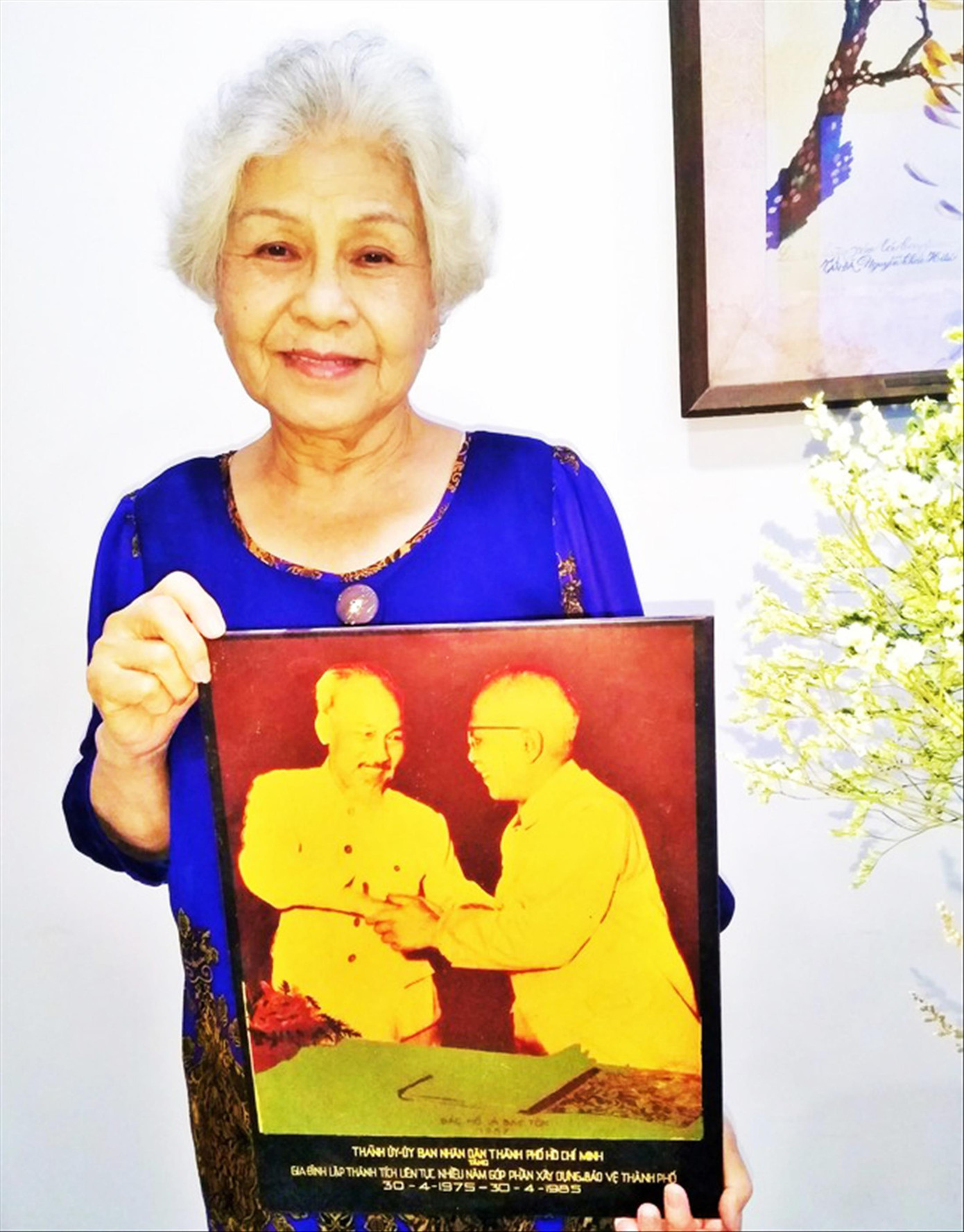 Nghệ sĩ Ưu tú Ca Lê Hồng với tấm ảnh Bác Hồ, Bác Tôn Ảnh: Trần Nguyễn Anh