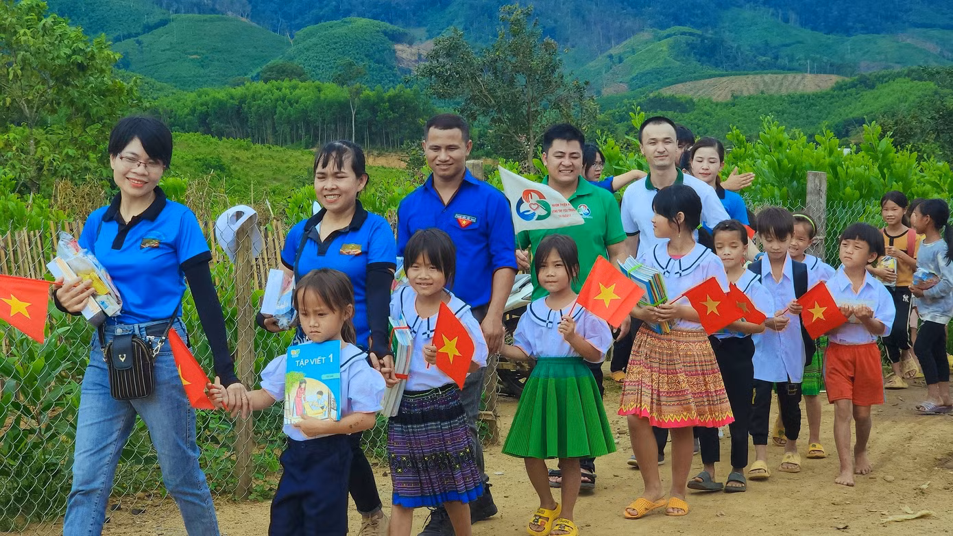 Các em học sinh hạnh phúc khi được tặng sách vở và áo trắng