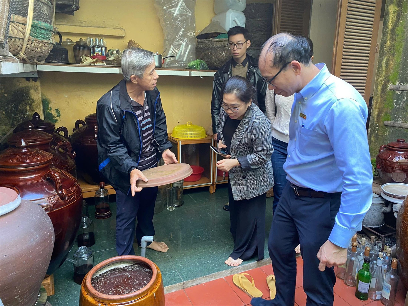 Tiến sĩ Phạm Châu Huỳnh cùng cộng sự tham quan quy trình sản xuất mắm nhỉ tại nhà ông Mười