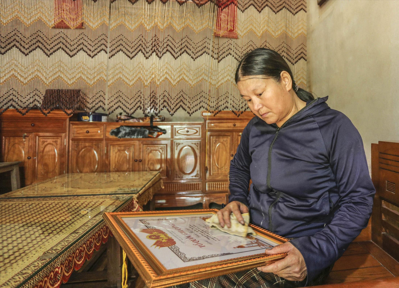 Bà Trần Thị Hà - mẹ liệt sĩ Trần Bá Diệu nâng niu tấm bằng Tổ quốc ghi công của con.