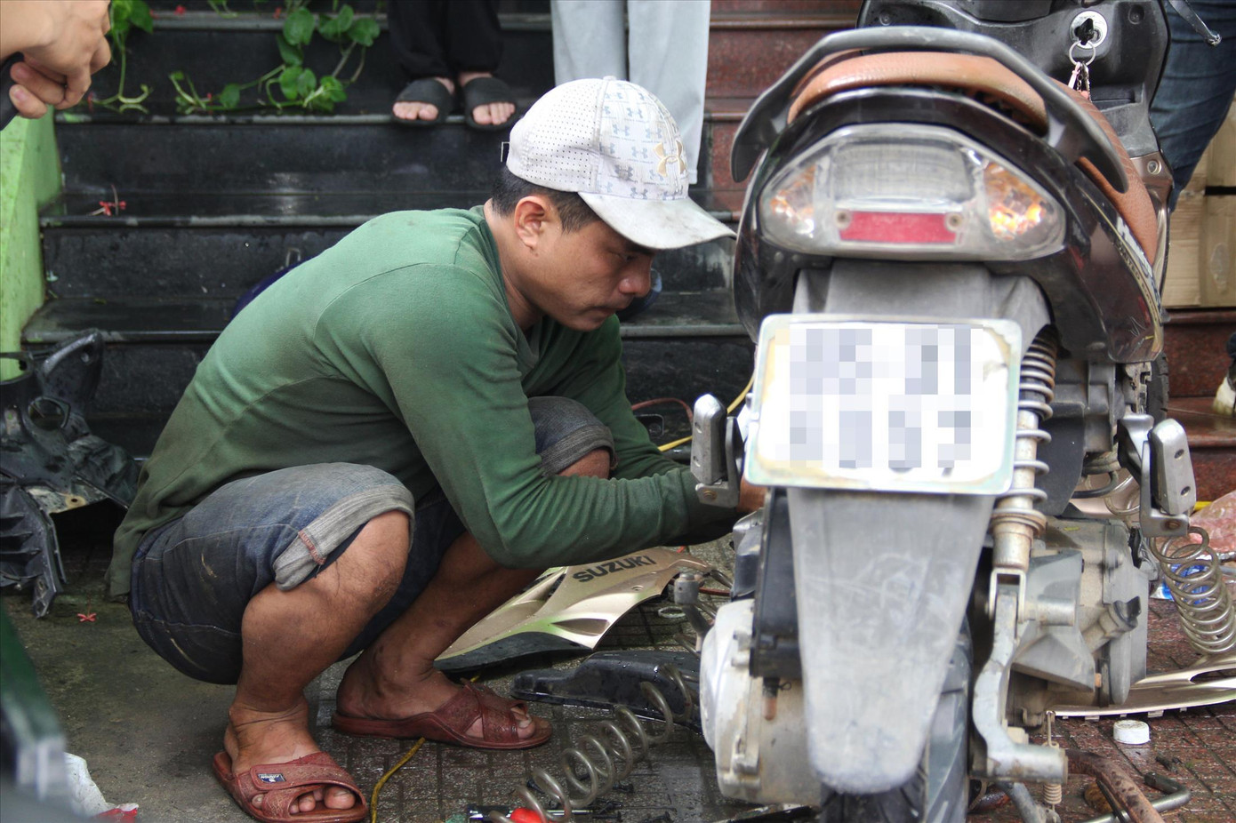 Đặng Văn Tiến (27 tuổi, thợ sửa xe) cùng đồng nghiệp lặn lội từ Nông Sơn (Quảng Nam) xuống Đà Nẵng sửa xe miễn phí Ảnh: Giang Thanh