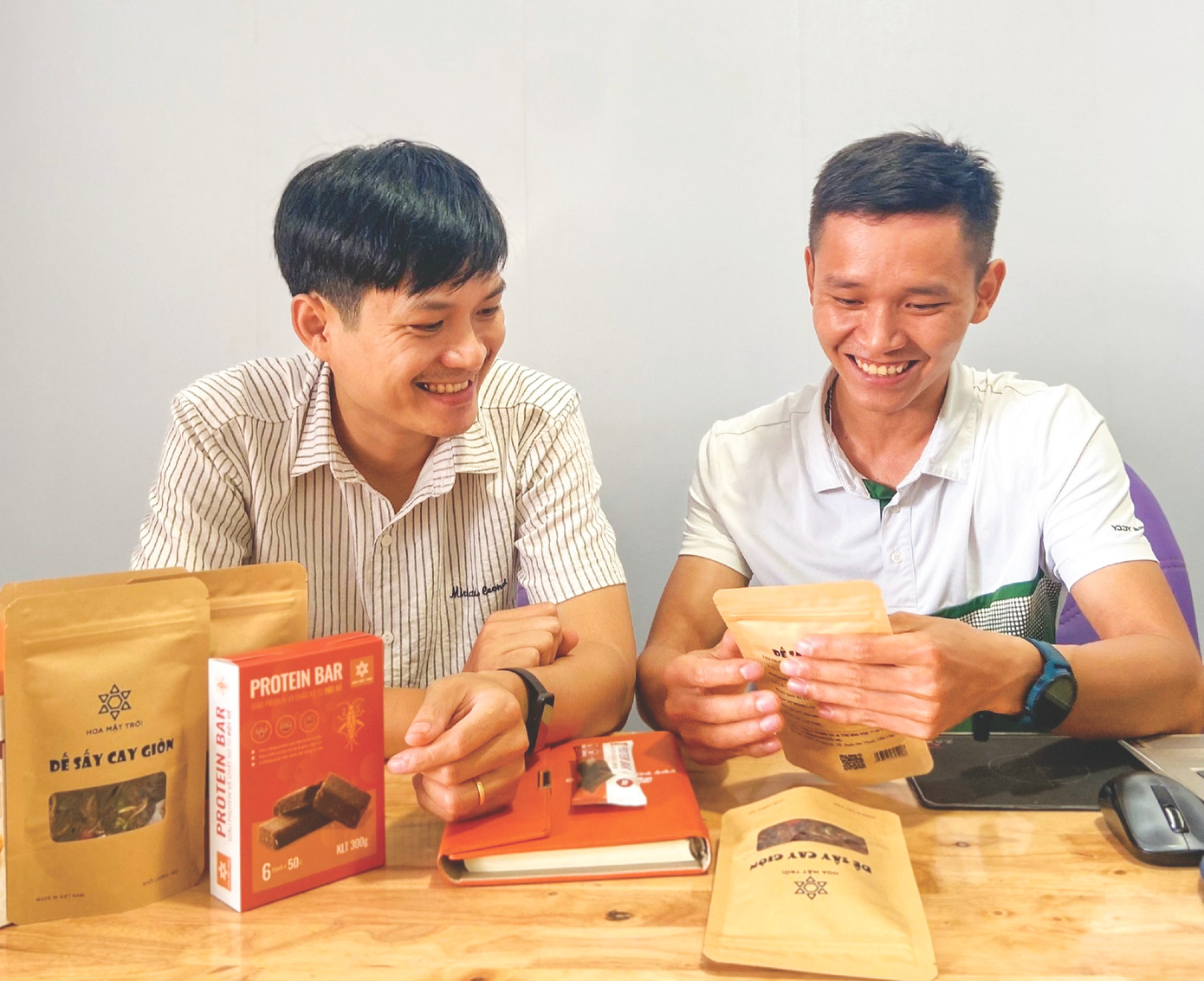 Anh Đặng Đình Luân (trái) cùng cộng sự đang trao đổi về các sản phẩm