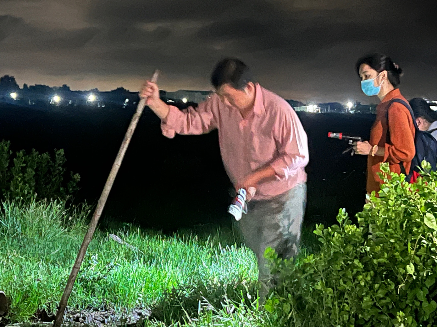 Nhân viên y tế lội ruộng đi bắt muỗi lúc nửa đêm.