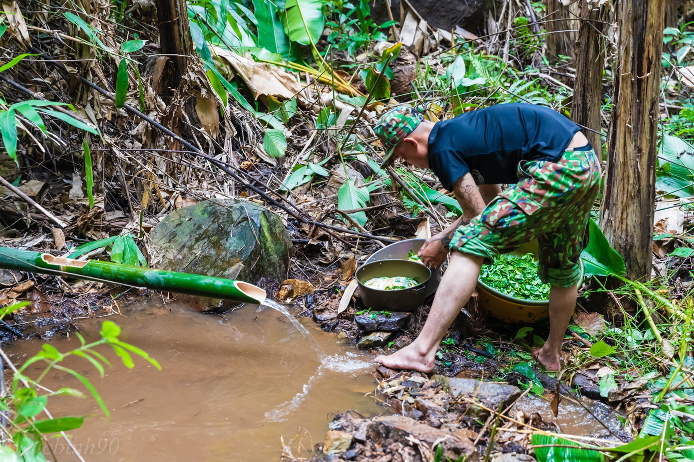Anh nuôi chặt trúc dẫn nước nấu cơm trong rừng, phục vụ đoàn đi tìm mộ liệt sĩ ở Chư Tan Kra.