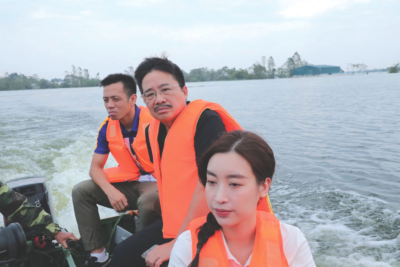 Hoa hậu Đỗ Mỹ Linh trên ca nô vào vùng lũ Chương Mỹ, Hà Nội cùng đoàn thiện nguyện do nhà báo Vũ Tiến, Phó Tổng Biên tập báo Tiền Phong dẫn đầu. Ảnh Nguyễn Hải