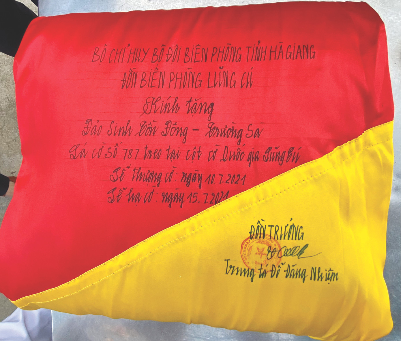 Lời đề tặng trên cờ 54 m2 của Đồn biên phòng Lũng Cú gửi đảo Sinh Tồn Đông. Ảnh: Lê Xuân Sơn Lời đề tặng trên cờ 54 m2 của Đồn biên phòng Lũng Cú gửi đảo Sinh Tồn Đông. Ảnh: Lê Xuân Sơn