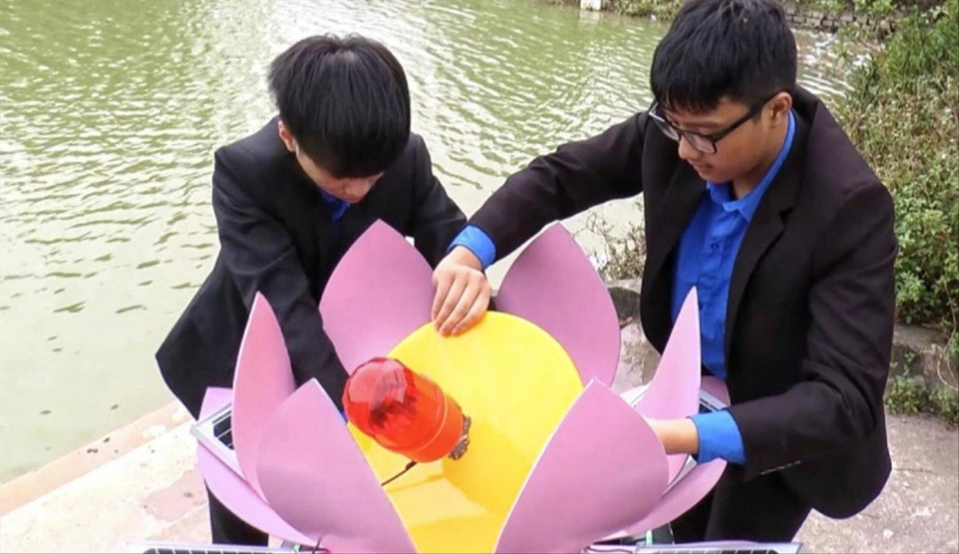 Hai em Hiếu (bên trái) và Đạt lắp ráp sản phẩm trước khi đưa xuống hồ chạy thử nghiệm