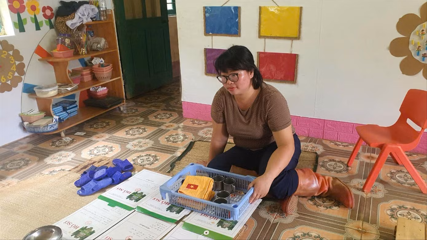 Cô giáo Hoàng Thị Nự bên cạnh kỷ vật của những học sinh đã qua đời trong vụ sạt lở tại thôn Làng Nủ.