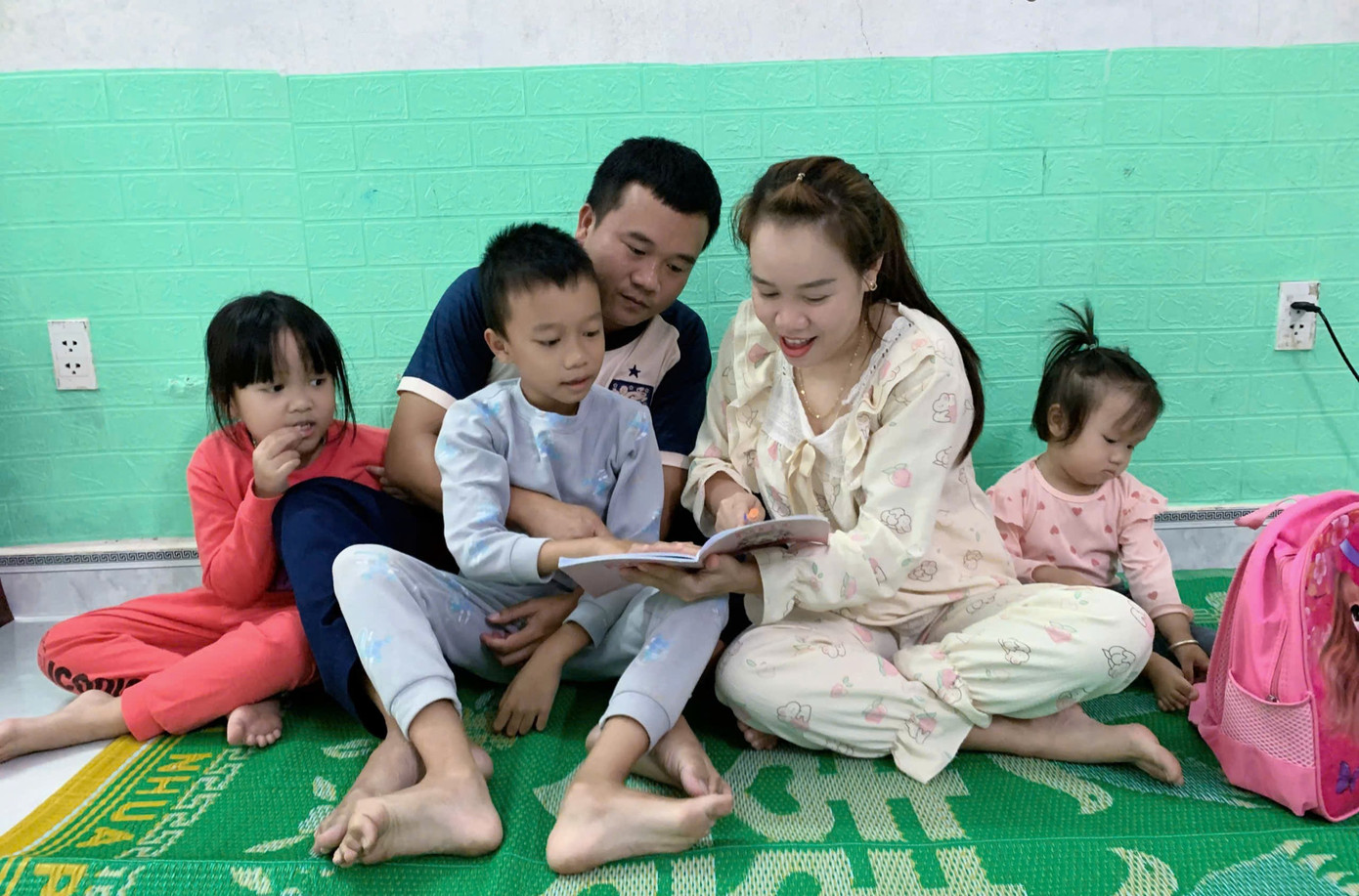 Vợ chồng Thiếu tá Trần Tấn Vũ dạy con trai Trần Khôi Vĩ nhận biết chữ cái trong sách.