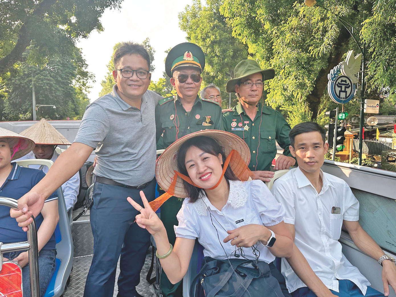 Tác giả (đứng) cùng các bác thương binh trên xe buýt hai tầng thăm Hà Nội