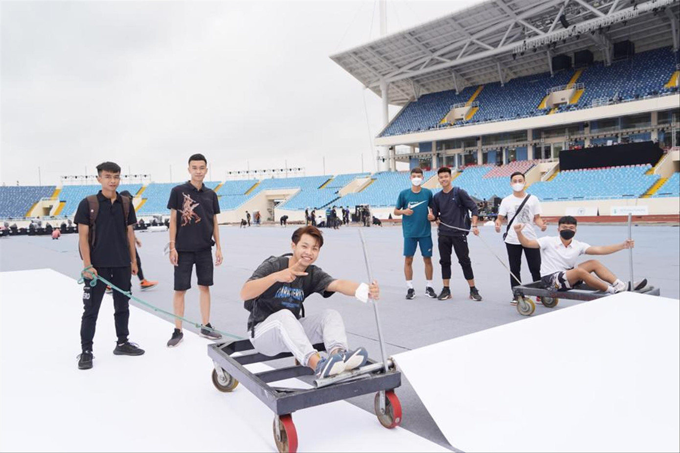 Khoảnh khắc người trẻ tình nguyện trải thảm sân khấu bảo vệ sân cỏ Mỹ Đình chuẩn bị cho lễ khai mạc SEA Games 31. Ảnh: Kỳ Sơn