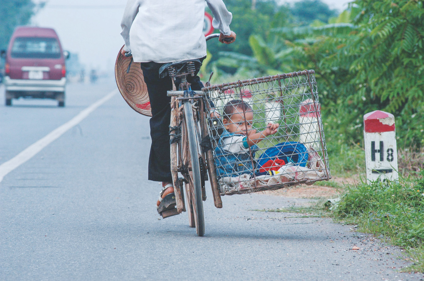 Người mẹ chở con về nhà sau buổi chợ. Ảnh chụp trên đường Láng - Hòa Lạc, nay là Đại lộ Thăng Long, đoạn qua huyện Thạch Thất Người mẹ chở con về nhà sau buổi chợ. Ảnh chụp trên đường Láng - Hòa Lạc, nay là Đại lộ Thăng Long, đoạn qua huyện Thạch Thất