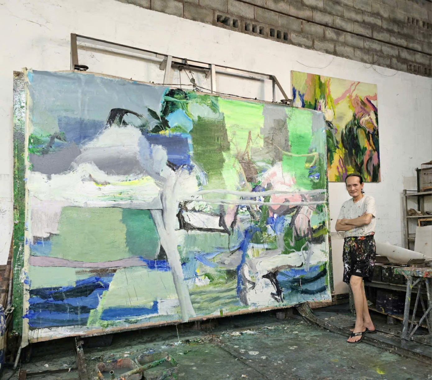 Hoạ sĩ Trần Hải Minh bên bức tranh “Chuyển động 3”