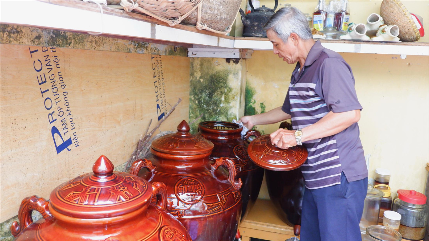 Ông Mười chăm chút những chum mắm để đảm bảo sạch sẽ nhất Ảnh: Nguyễn Thành