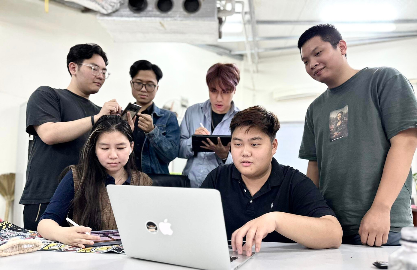 Bạn Duy Đức (ngồi) cùng đồng nghiệp thảo luận về dự án sắp tới. Ảnh: PV