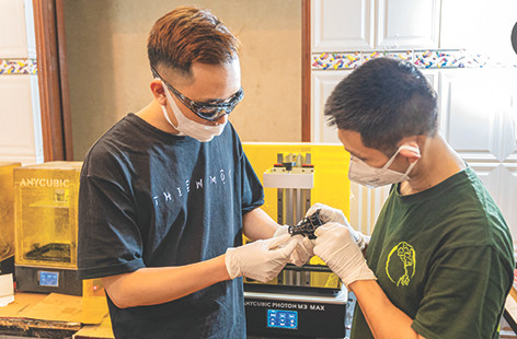 Hoàng Anh Tuấn (bên trái) đang vận hành máy in 3D Hoàng Anh Tuấn (bên trái) đang vận hành máy in 3D