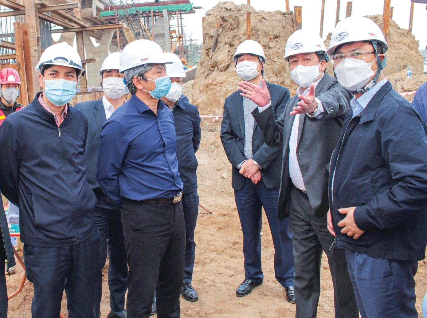 Phó Chủ tịch UBND TP Hà Nội Dương Đức Tuấn (người giơ tay về phía trước kiểm tra tiến độ), Giám đốc Ban Giao thông Nguyễn Chí Cường (người đứng đầu tiên bên phải) và đại diện các sở ngành Hà Nội tại dự án cầu Vĩnh Tuy 2 chiều 7/1 Ảnh: T.Đảng