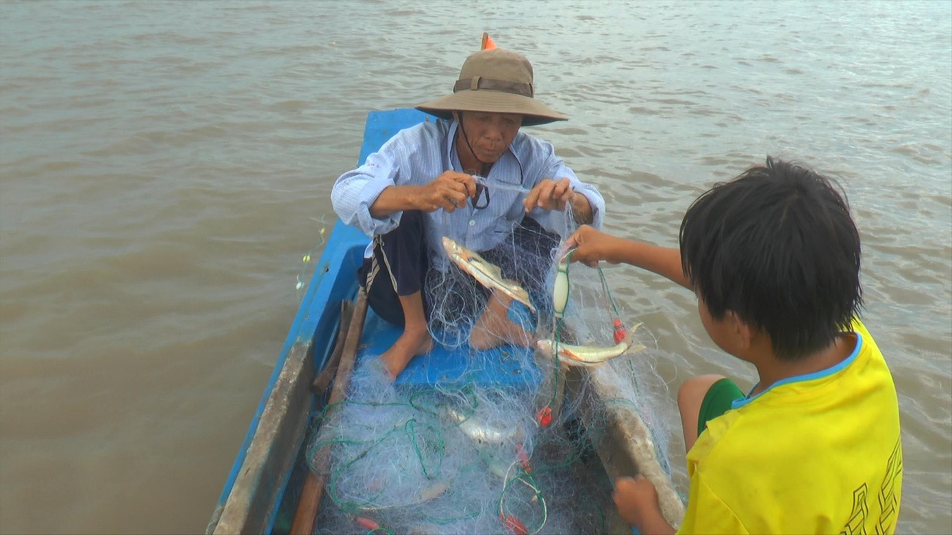 Ông “Út què” cùng đứa cháu nội ra biển mưu sinh (ảnh trái); Chị Thi dù bị khiếm thị nhưng vá lưới nhanh hơn người sáng mắt (ảnh phải)