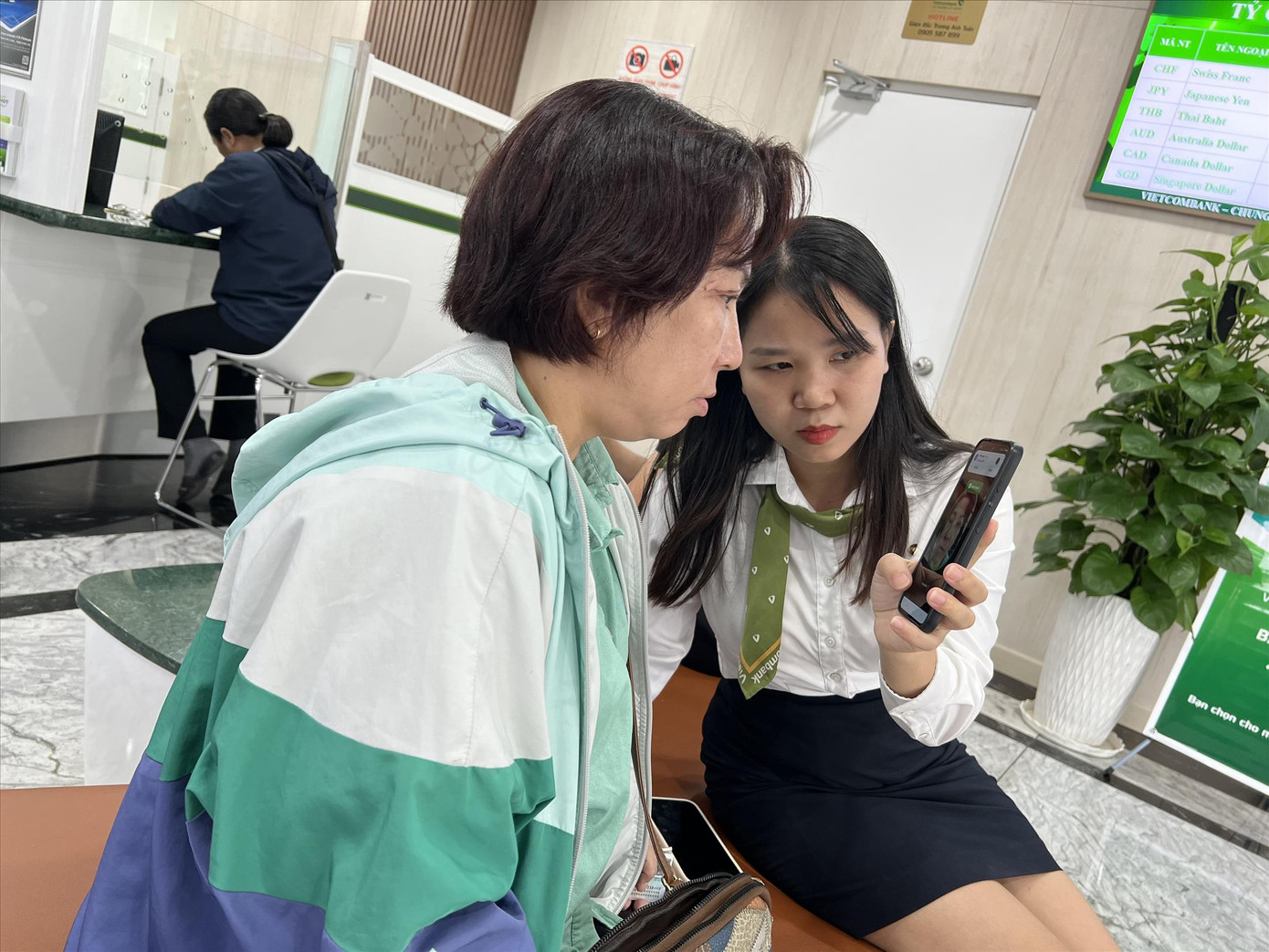 Nhân viên ngân hàng hướng dẫn khách xác nhận sinh trắc học. Ảnh: U.P Nhân viên ngân hàng hướng dẫn khách xác nhận sinh trắc học. Ảnh: U.P