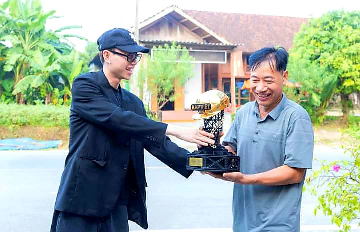 Ông Bùi Văn Tường đón cup Quán quân Rap Việt từ tay con trai.