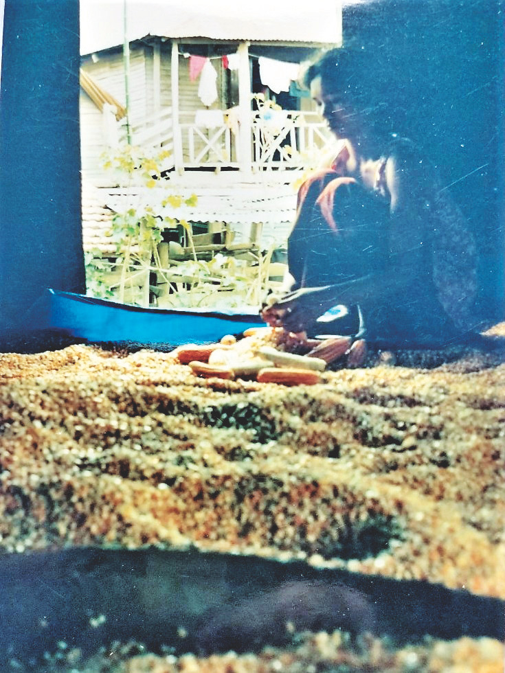 Chị H’Beng đang tách hạt bắp mới thu hoạch trong căn nhà của mình Chị H’Beng đang tách hạt bắp mới thu hoạch trong căn nhà của mình