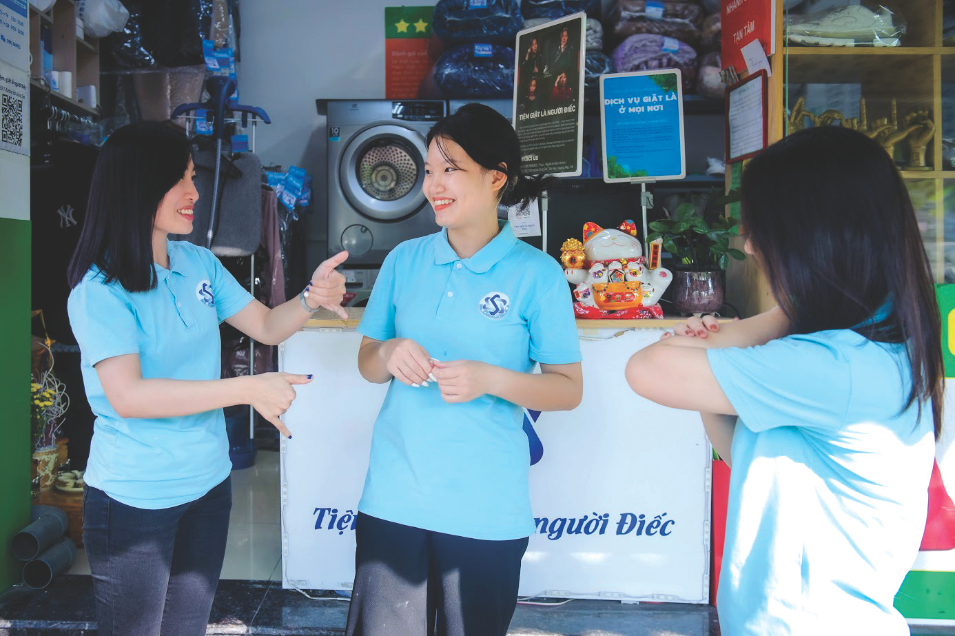 Chị Lương Thị Kiều Thúy (ngoài cùng bên trái) và các nhân viên chuyện trò qua ngôn ngữ ký hiệu