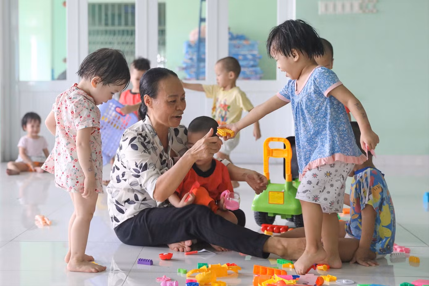 Các bảo mẫu của Trung tâm bảo trợ trẻ em Tam Bình dành nhiều thời gian dỗ dành để trẻ ổn định tâm lý. Ảnh: Duy Anh