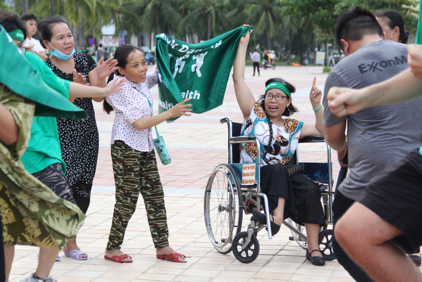 Dù ngồi xe lăn, chị Đặng Thị Bé vẫn lắc lư theo những giai điệu sôi động. - Ảnh: Giang Thanh