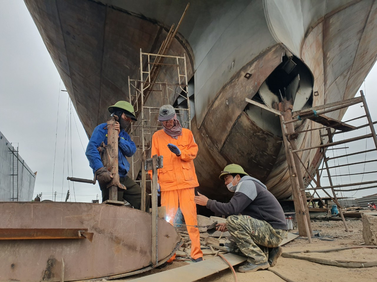Công nhân lành nghề đang hàn thành vỏ tàu Công nhân lành nghề đang hàn thành vỏ tàu