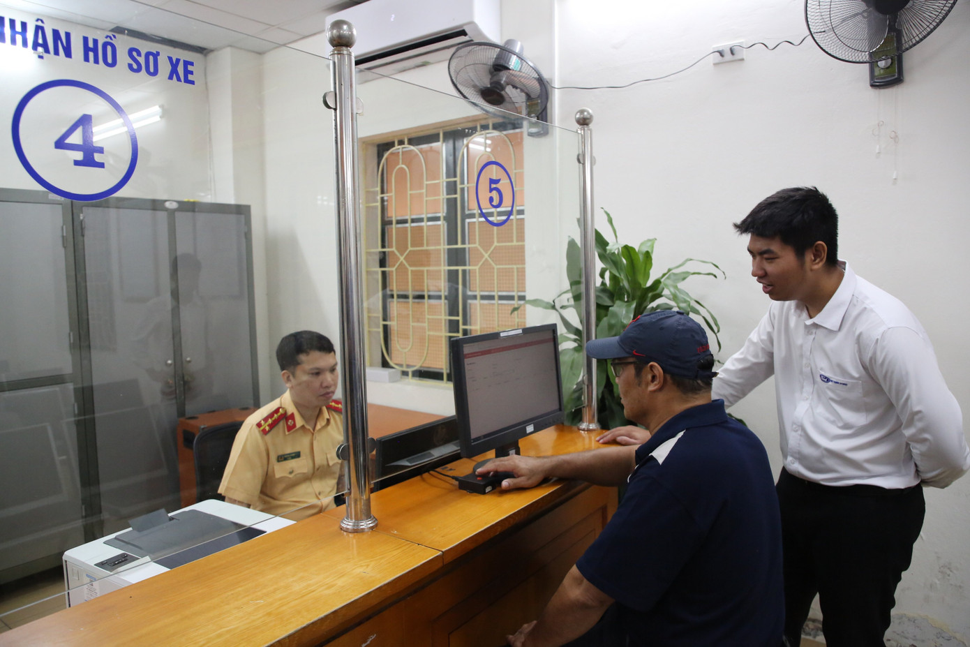 Người dân làm thủ tục bấm biển số. Người dân làm thủ tục bấm biển số.