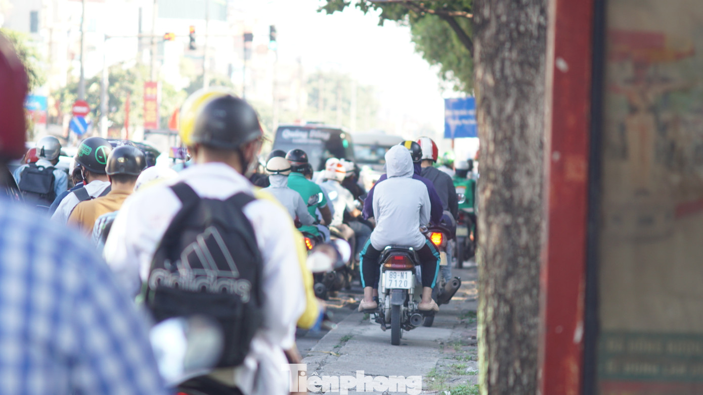 Một số tài xế xe máy đi lên vỉa hè để nhanh chóng qua khu vực ùn tắc.