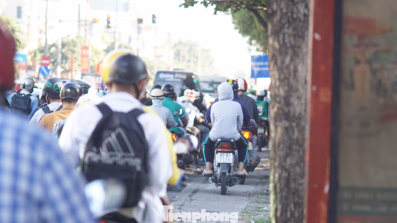 Một số tài xế xe máy đi lên vỉa hè để nhanh chóng qua khu vực ùn tắc.